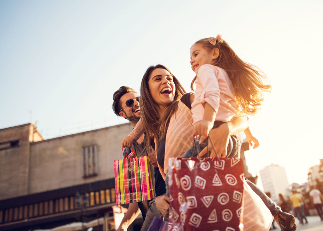 family shopping outdoors with shopping bags