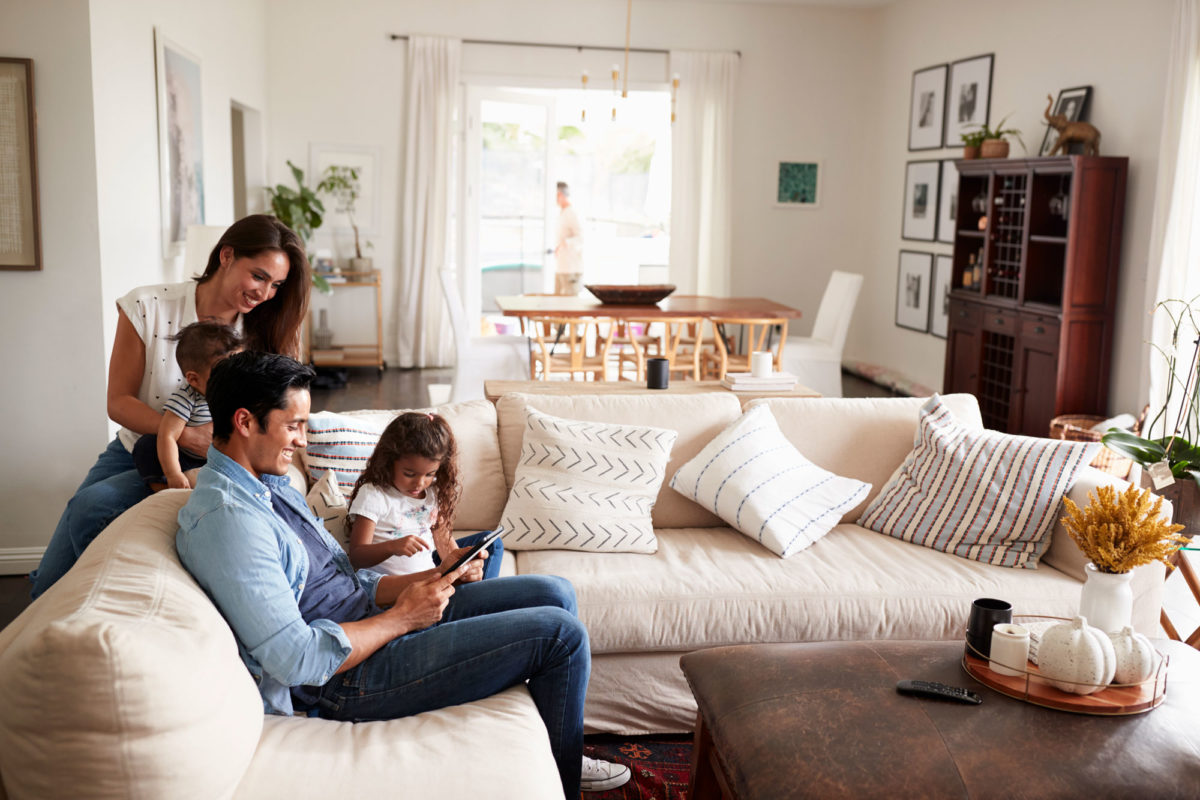 family on living room couch with tablet