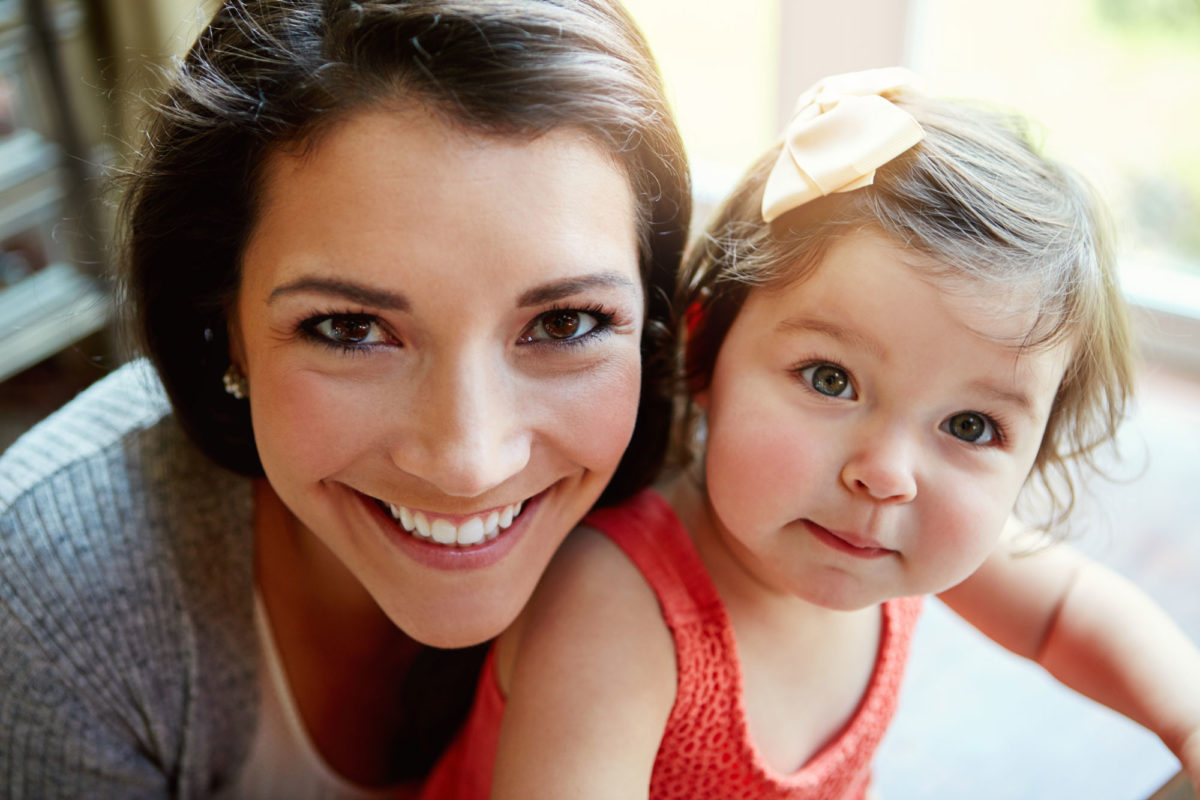 woman smiling with her baby daughter